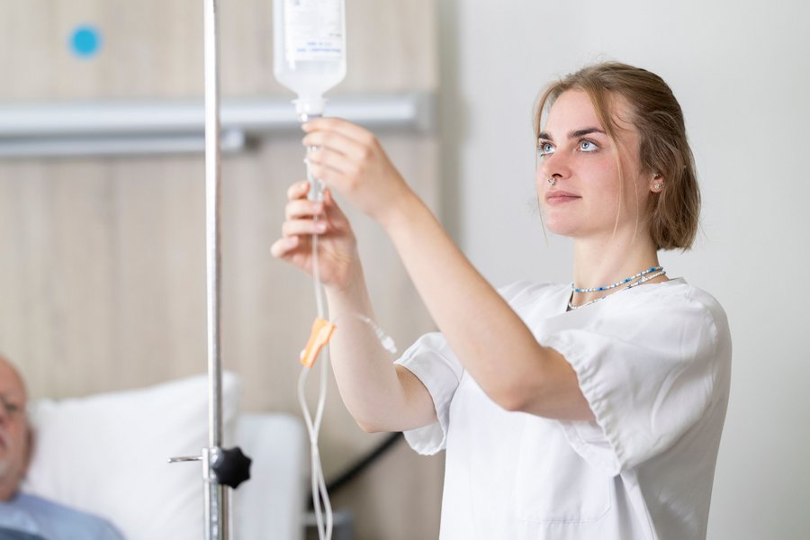 Eine junge Pflegerin bereitet einen Tropf vor
