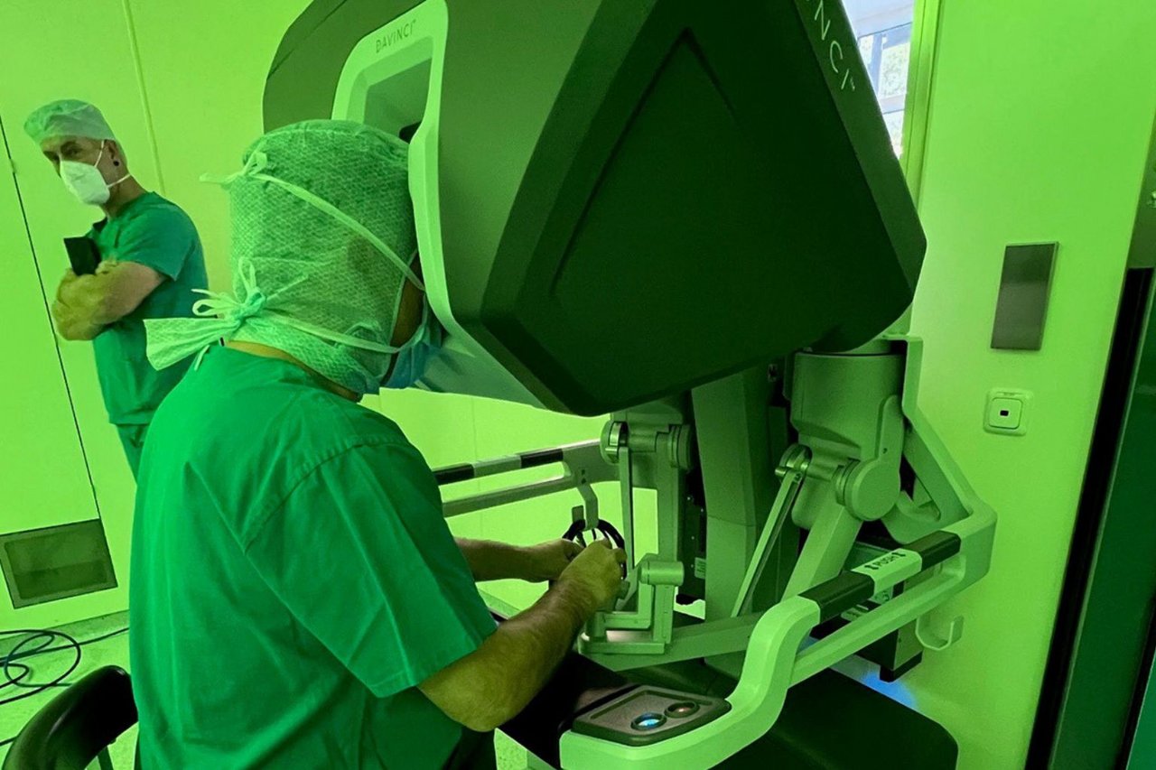 Chirurg sitzt an der Steuerkonsole eines da Vinci-Operationssystems und bedient die robotische Chirurgieanlage.