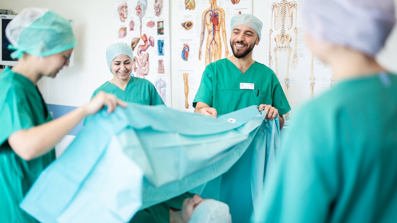 Praxisanleitende im OP zeigen Azubis wie man einen OP vorbereitet