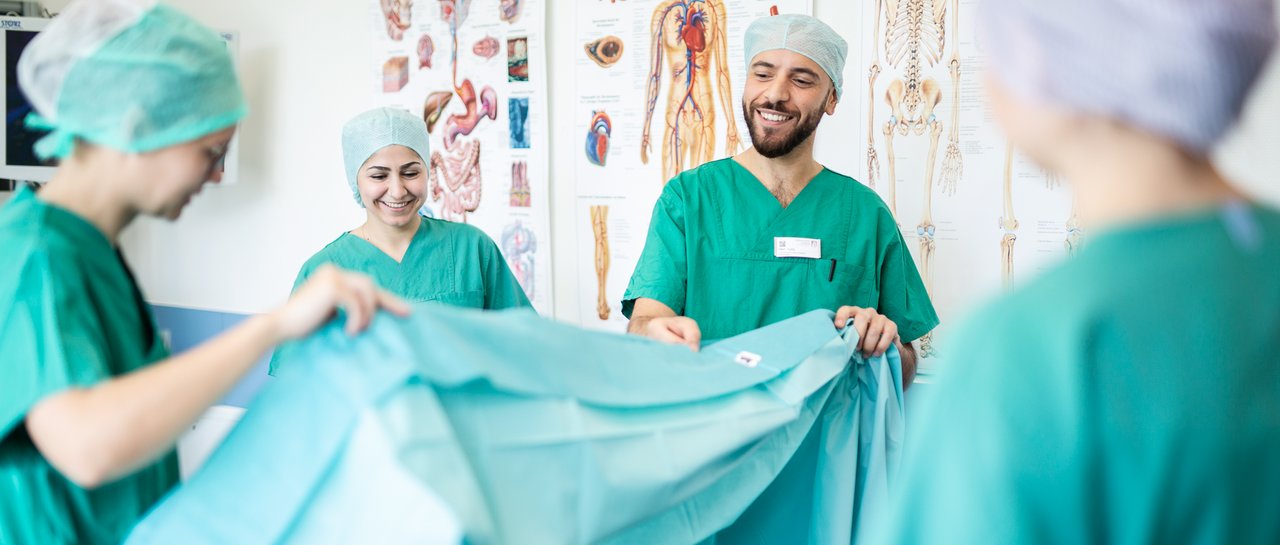 Praxisanleitende im OP zeigen Azubis wie man einen OP vorbereitet