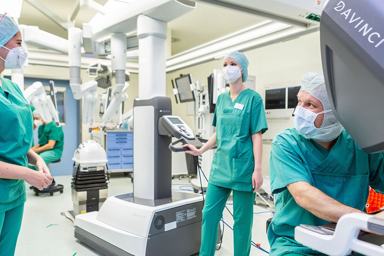 Ein Operateur und OTAs im OP mit dem Da Vinci Roboter
