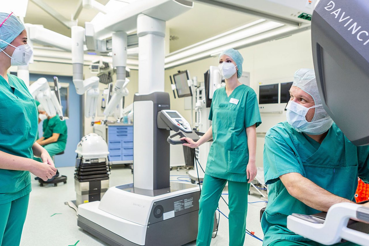 Ein Operateur und OTAs im OP mit dem Da Vinci Roboter
