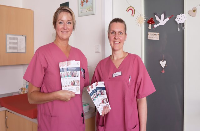 2 Pflegerinnen halten einen Flyer hoch