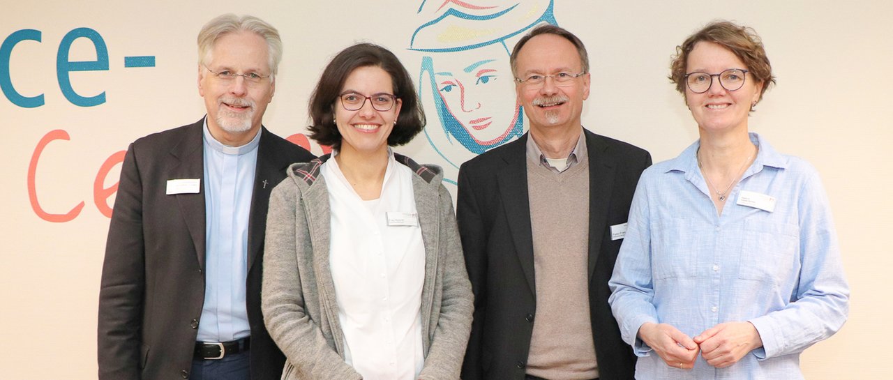 Gruppenbild von vier Seelsorgenden, die vor einer Wand stehen