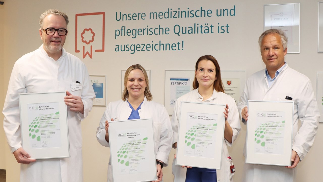 Vier Mitarbeitende des Krankenhauses Reinbek in weißen Kitteln stehen nebeneinander und halten gerahmte Zertifikate für die Krebsbehandlung in den Händen.