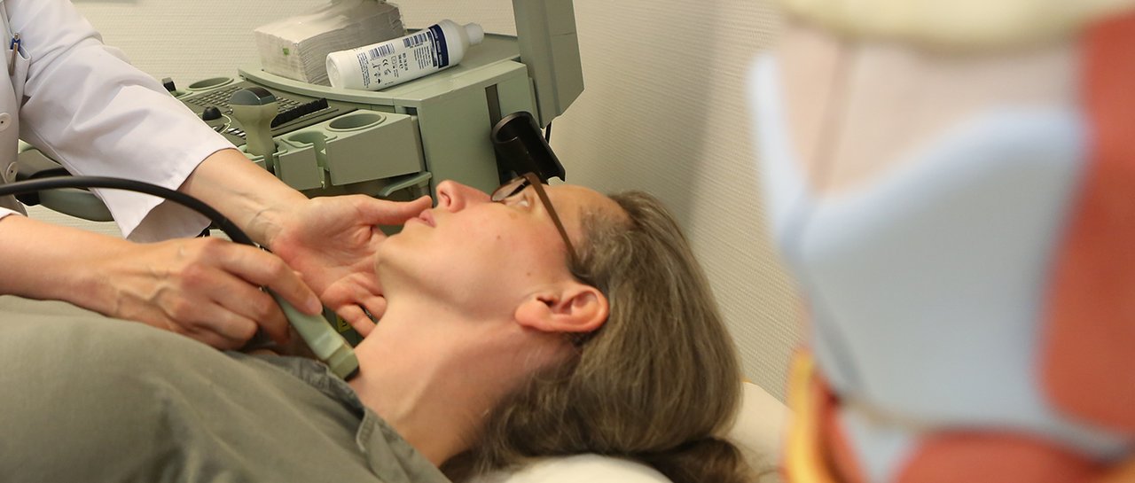Eine Patientin bekommt einen Ultraschall am Hals