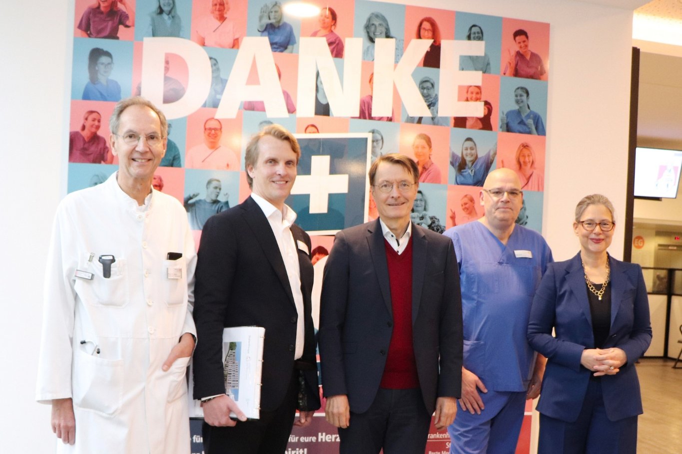 Mehrere Personen stehen im Foyer eines Krankenhauses vor einer farbigen Collage mit dem Schriftzug „DANKE“. Die Gruppe besteht aus medizinischem Fachpersonal in Arbeitskleidung, dem Geschäftsführer, dem Bundesgesundheitsminister Prof. Dr. Karl Lauterbach und er Bundestagsabgeordneten Dr. Nina Scheer zusammenstehend.