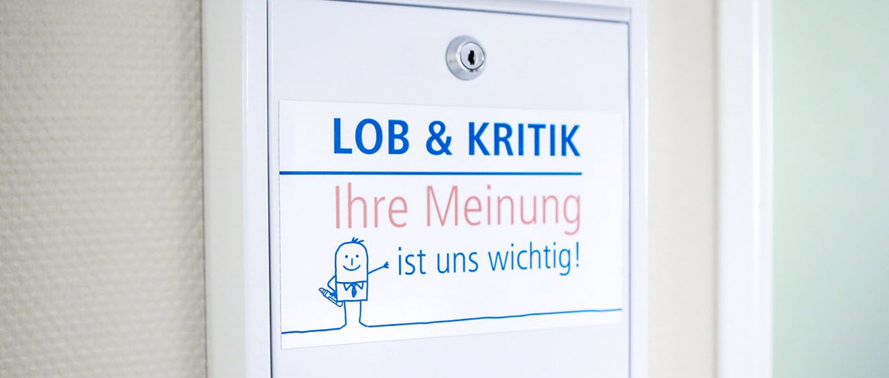 Ein Briefkasten mit der Aufschrift: Lob & Kritik Ihre Meinung ist uns wichtig!