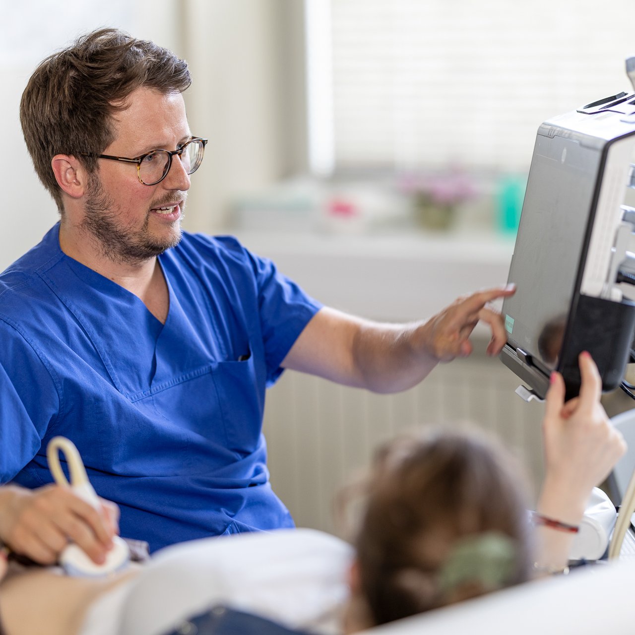 Ein Arzt macht einen Ultraschall bei einer Patientin