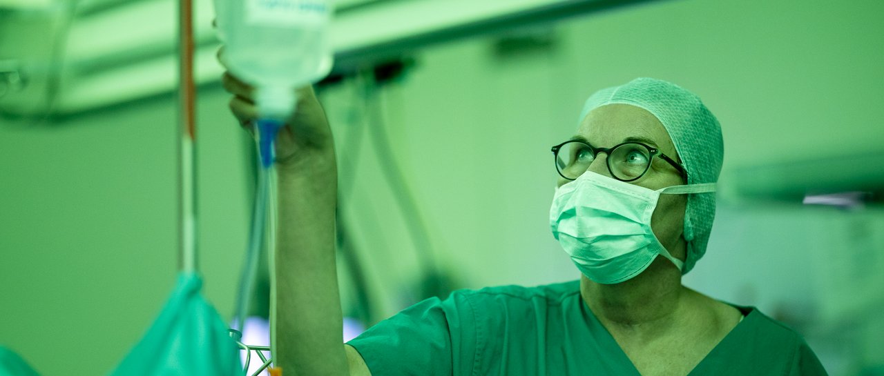 Eine Anästhesie Ärztin im OP schaut sich den Tropf an
