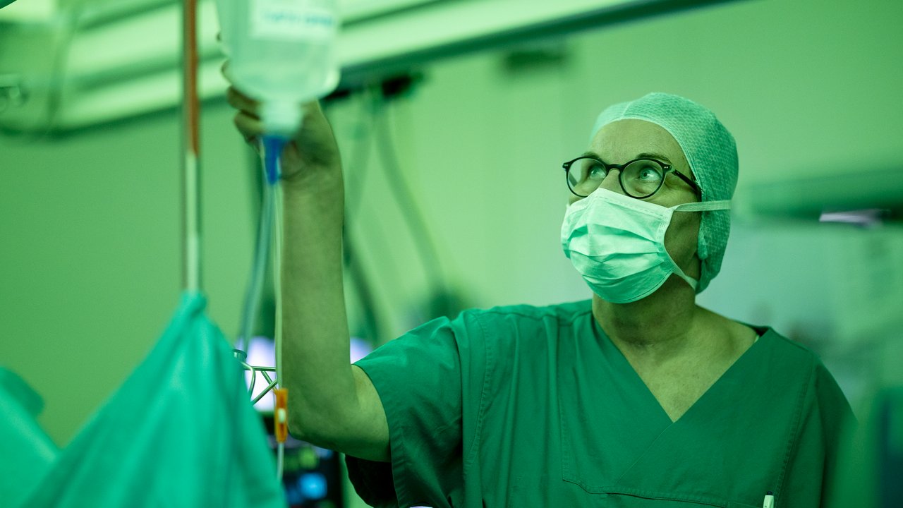 Eine Anästhesie Ärztin im OP schaut sich den Tropf an