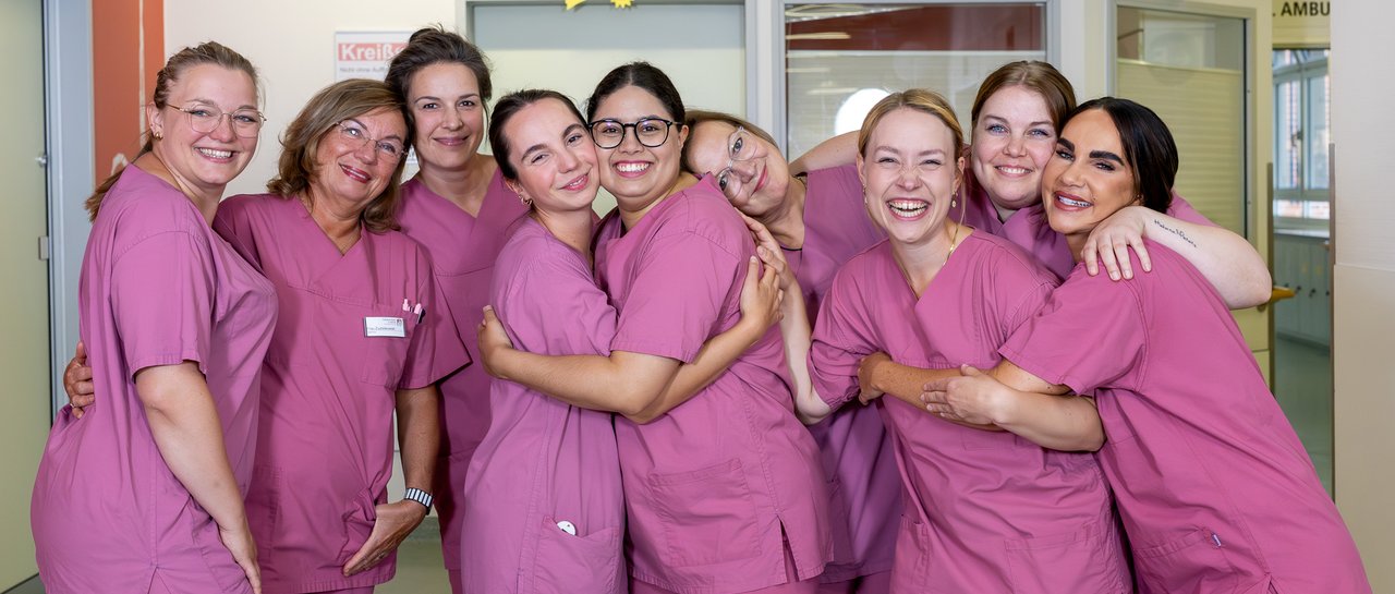 Gruppenfoto der Hebammen, alle liegen sich in den Armen und lachen