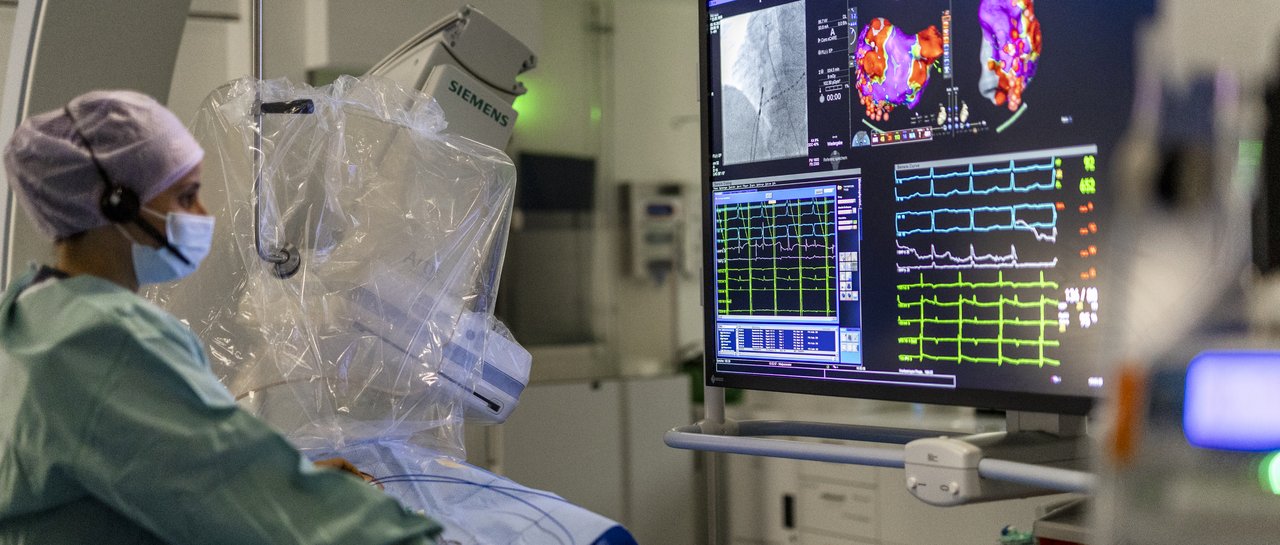 Oberärztin der Kardiologie in der Elektrophysiologie schaut auf den Monitor während des Eingriffs