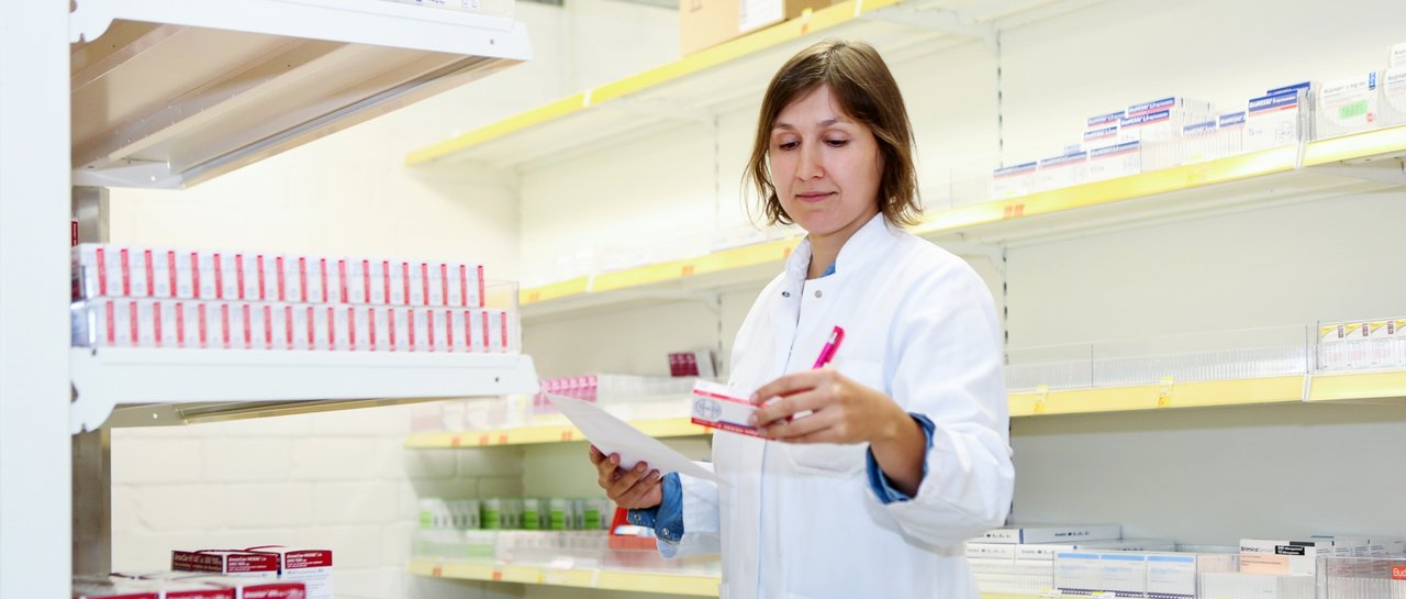 Eine Apothekerin schaut auf eine Verpackung