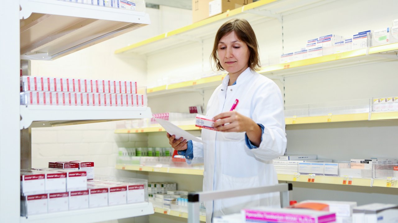 Eine Apothekerin schaut auf eine Verpackung
