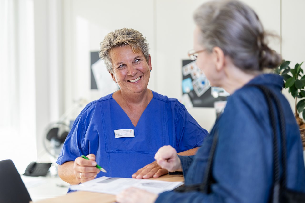 Eine Patientin am Tresen einer Anmeldung