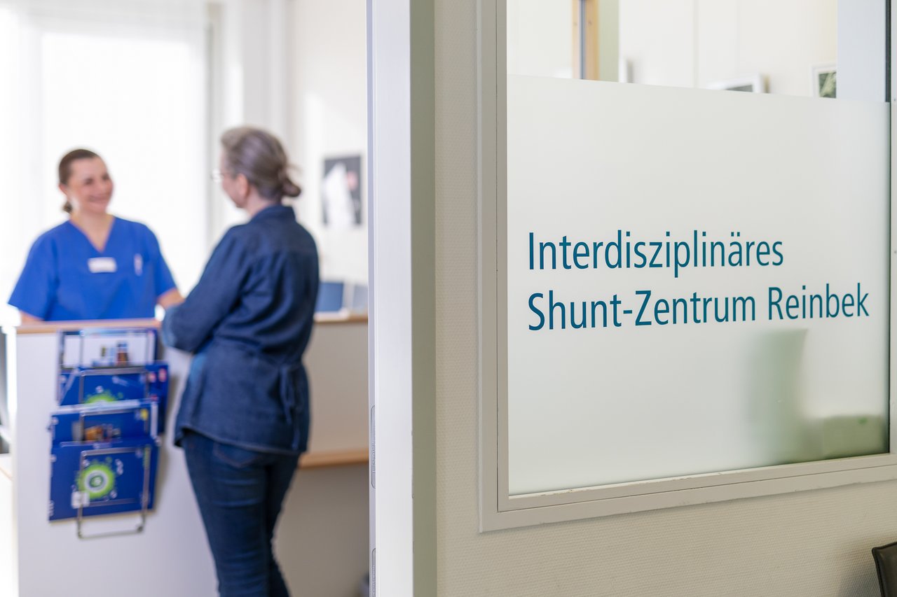 Eine Patientin am Tresen einer Anmeldung