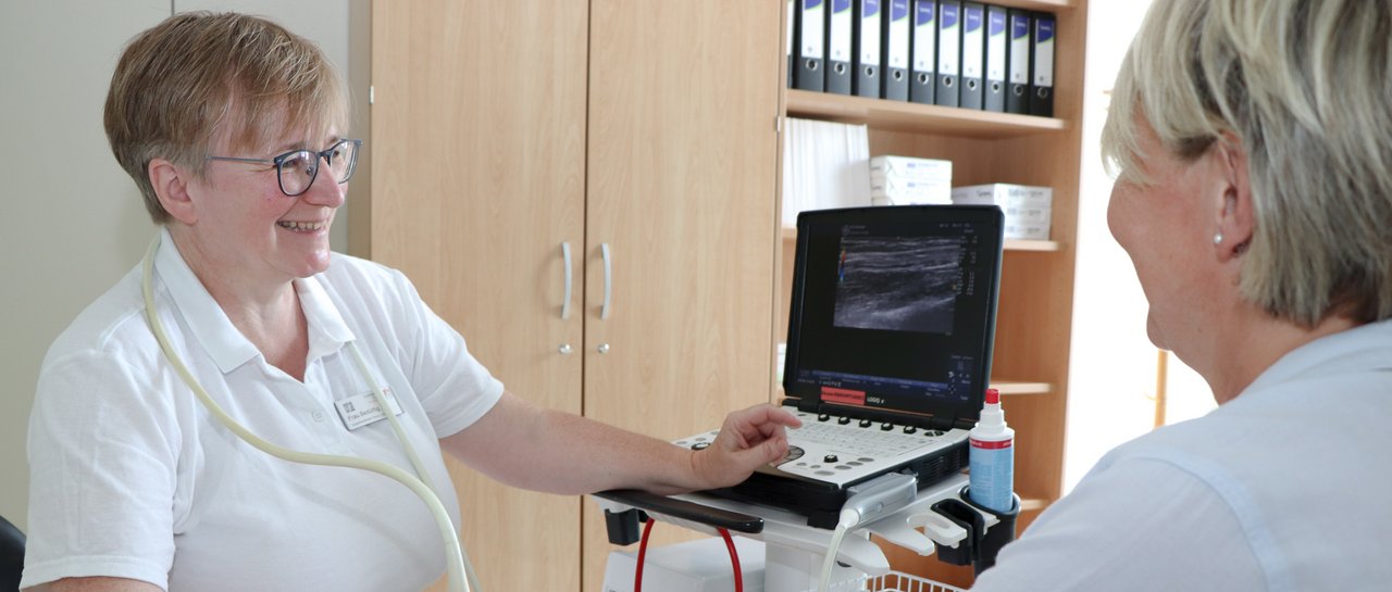 Eine Ärztin macht einen Ultraschal am Unterarm einer Patientin