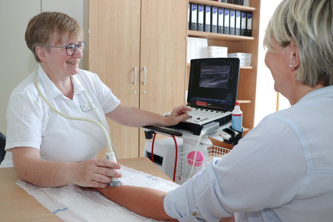 Eine Ärztin macht einen Ultraschal am Unterarm einer Patientin