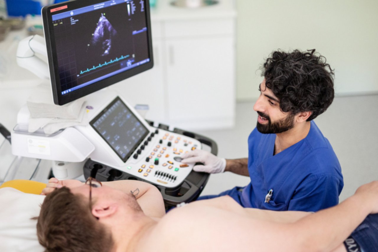 Ein Oberarzt der Kardiologie macht ein EKG an einem Pateinten