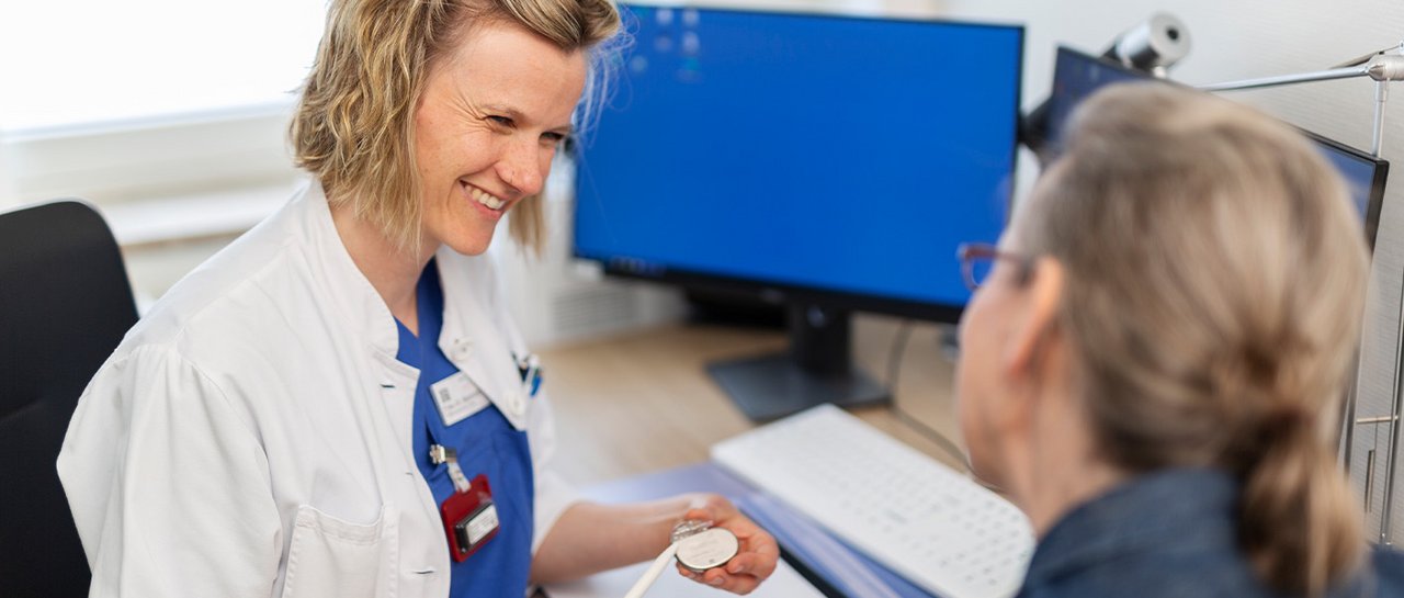 Eine Ärztin spricht freundlich mit einer Patientin und erläutert etwas