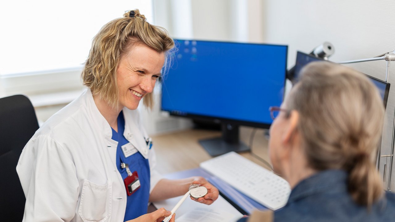 Eine Ärztin spricht freundlich mit einer Patientin und erläutert etwas