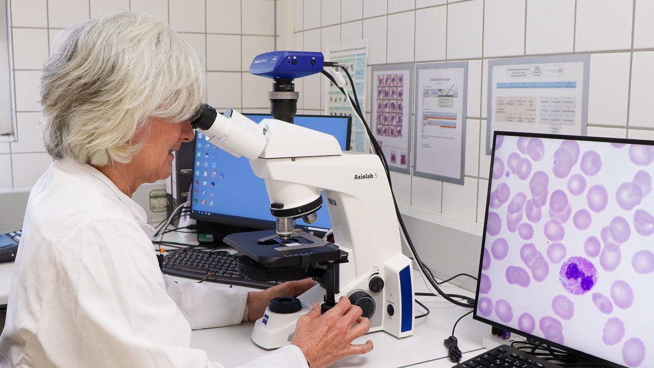 Eine Laborantin im Labor am Mikroskop