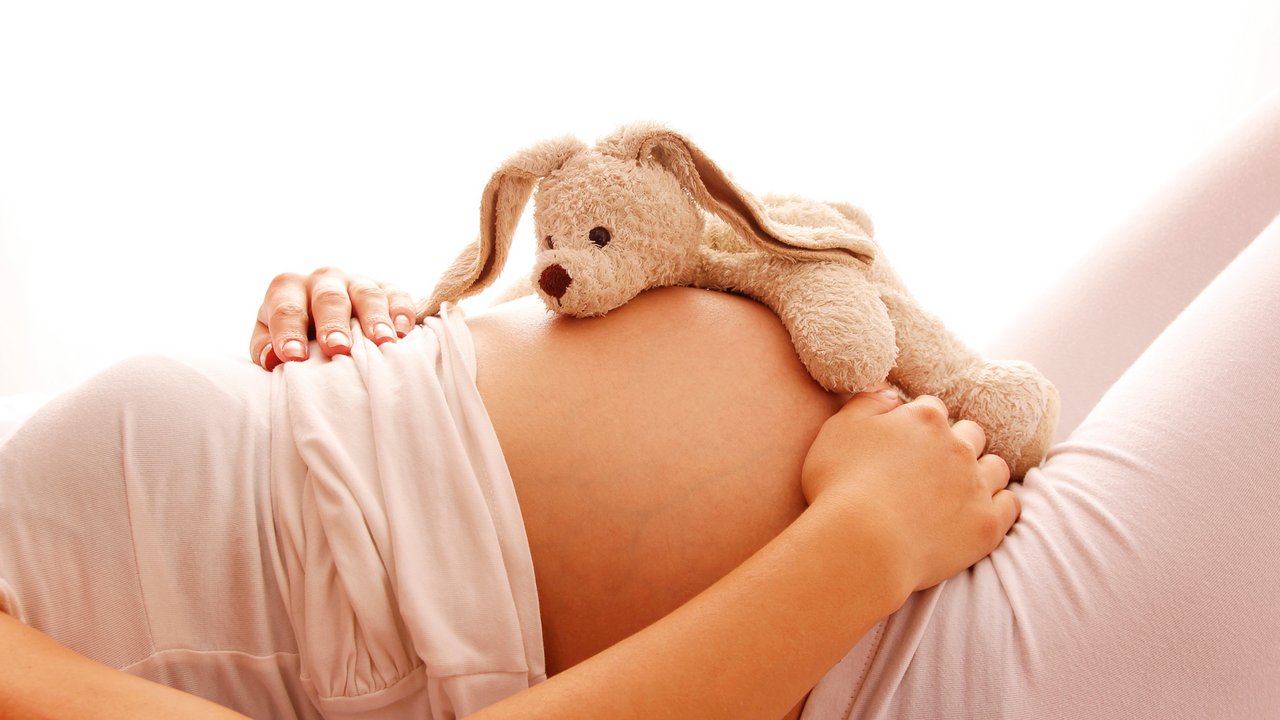 Stock Bild Teddy auf liegendem Schwangeren 