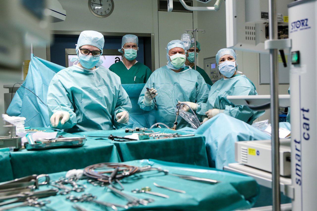 Ein Ärzteteam operiert einen Bauch, es werden Instrumente gehalten und konzentriert auf einen Bildschirm geschaut