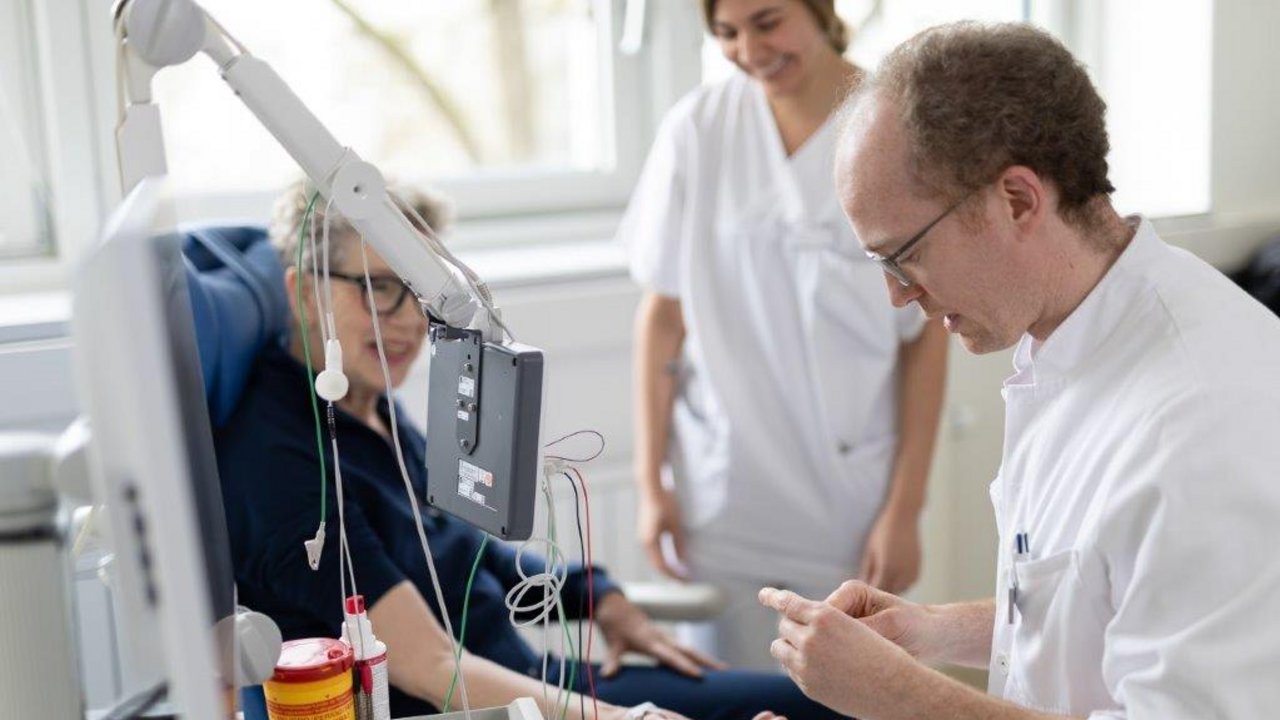 Ein Arzt führt eine Messung der Nervenbahnen an einer Neurologiepatientin durch