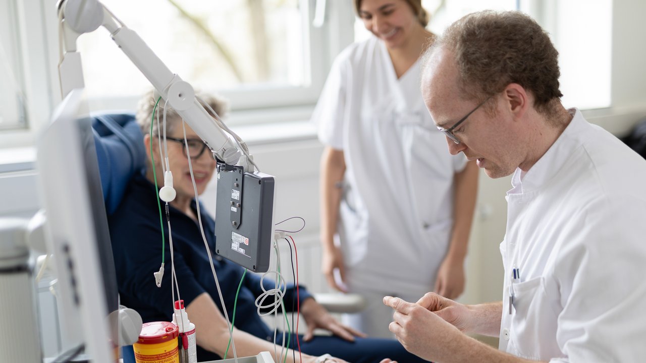 Ein Arzt führt eine Messung der Nervenbahnen an einer Neurologiepatientin durch