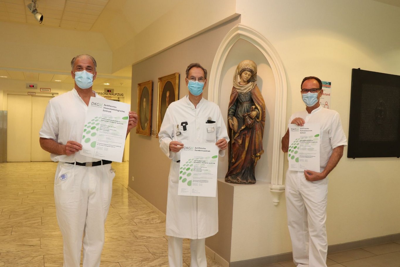 Drei Ärzte im Krankenhaus Reinbek St. Adolf-Stift halten Zertifikate der Deutschen Krebsgesellschaft für zertifizierte onkologische Zentren.
