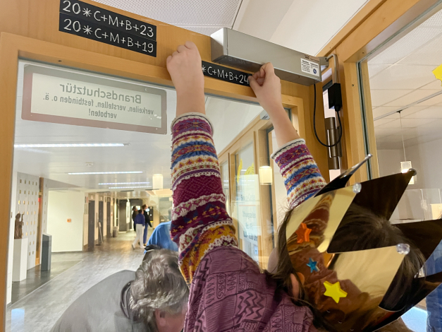 Sternsinger klebt Segen an Sternsinger klebt Segen an