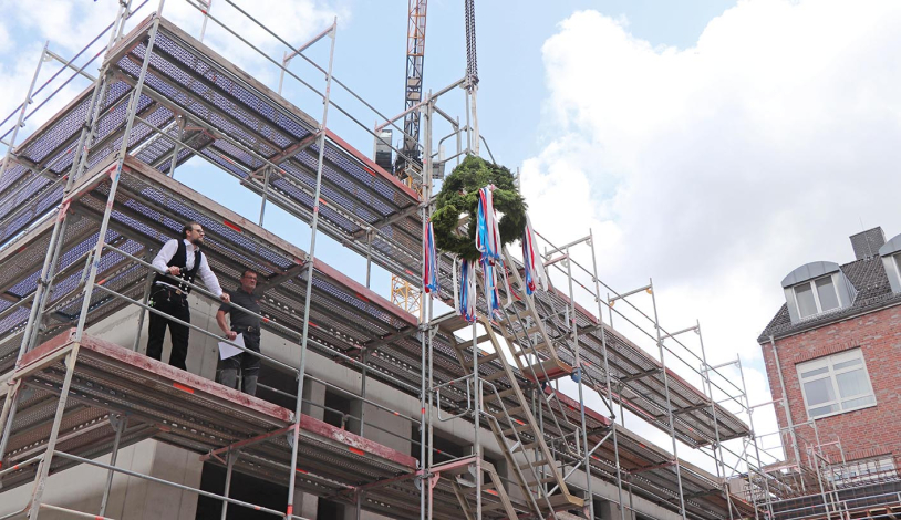 Polier und Richtkranz auf dem Gerüst des Neubaus