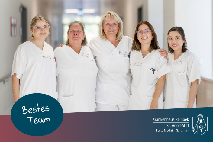 5 Pflegerinnen der Station 14 stehen auf dem Flur, lächeln und umarmen sich