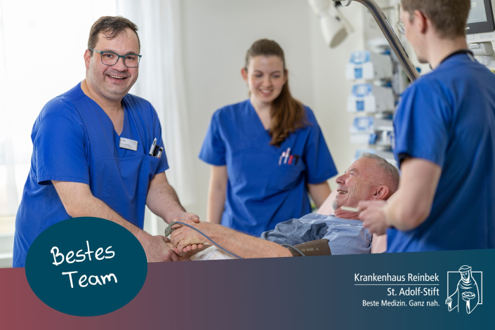 Pflegekräfte der Neurologie stehen am Patientenbett, einer hält die Hand des Patienten