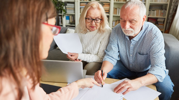 Stockbild: Eltern (Senioren) unterschreiben Dokumente, Tochter schaut mir drauf