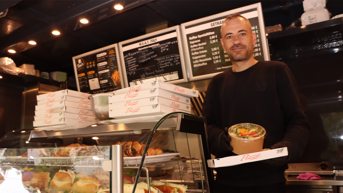 Ein Mann steht hinter dem Tresen eines Foodtrucks
