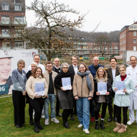 Lehrerinnen und Schüler:innen des Campus für Pflegeberufe mit Förderbescheiden