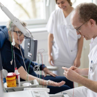 Ein Arzt führt eine Messung der Nervenbahnen an einer Neurologiepatientin durch