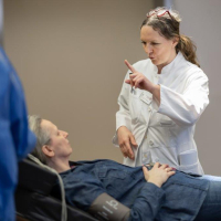 Eine Neurologieärztin führt einen Reaktionstest mit einer Schlaganfallpatientin in der Notaufnahme durch