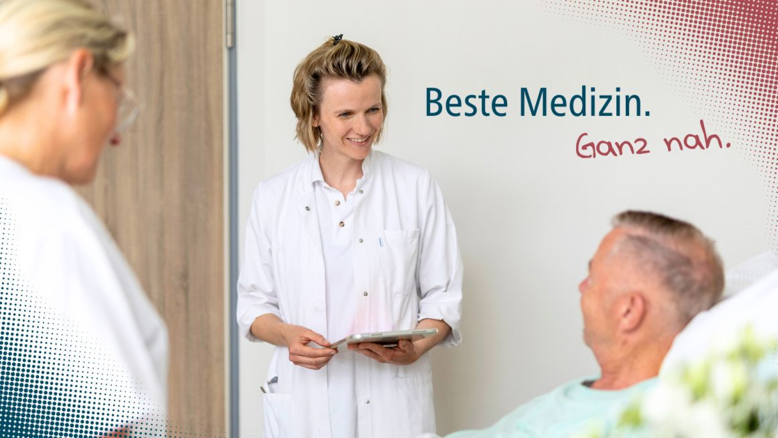 Frau Dr. Baumstark unterhält sich mit Patienten im Bett