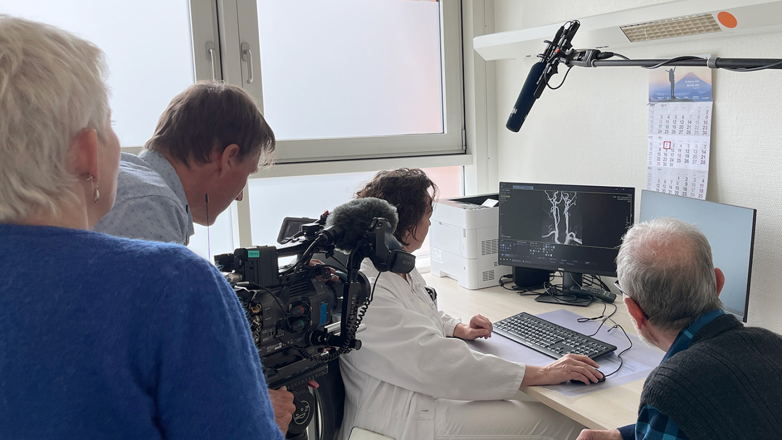 Dr Annette Sommerfeld im Untersuchungsraum mit Patienten und TV Team