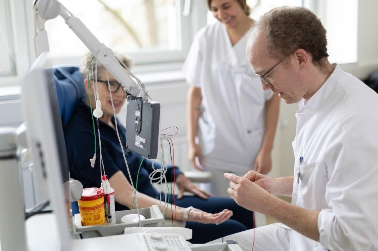 Ein Arzt führt eine Messung der Nervenbahnen an einer Neurologiepatientin durch