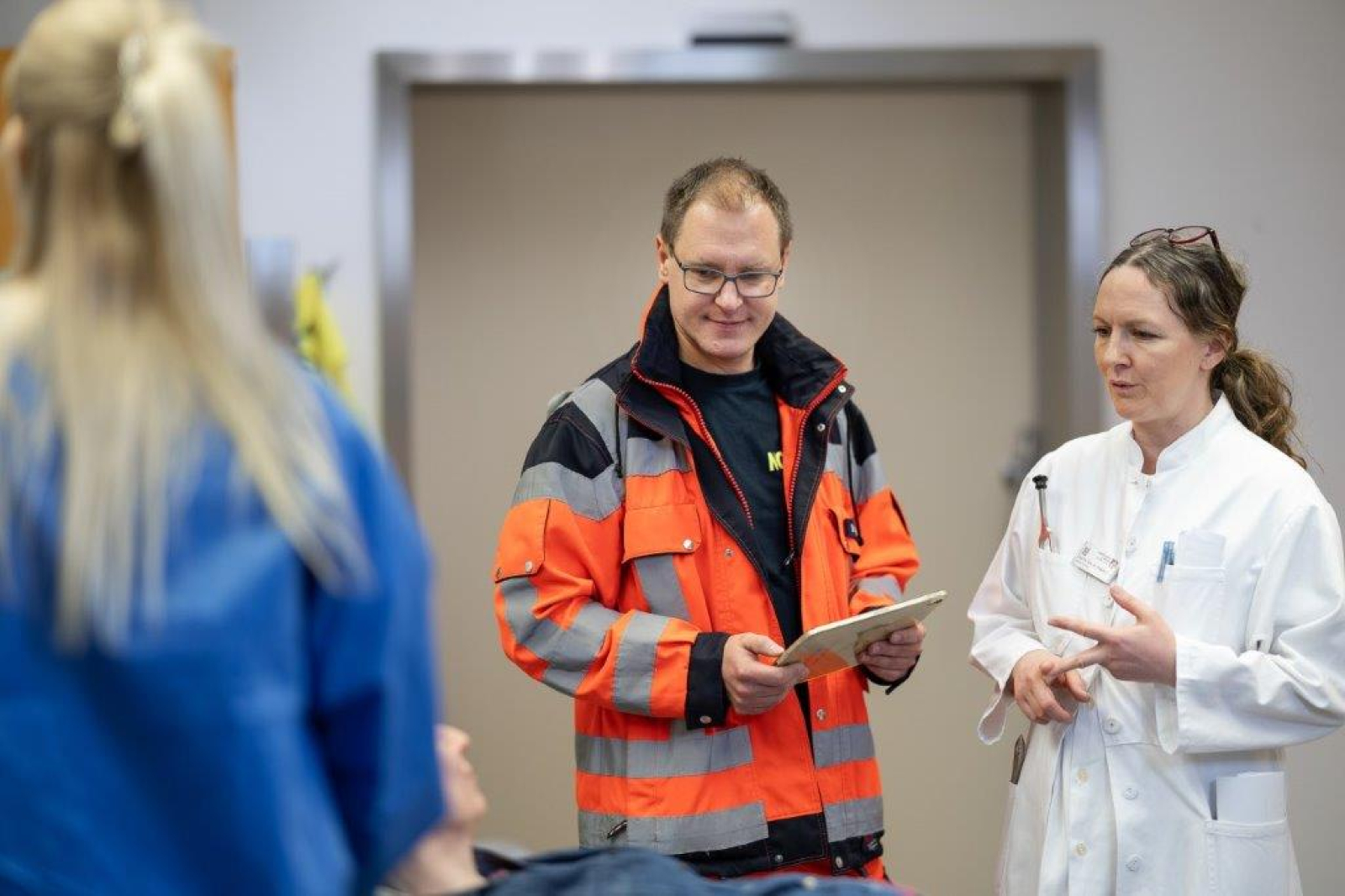 Ein Notarzt und eine Neurologieärztin sprechen in der Notaufnahme miteinander