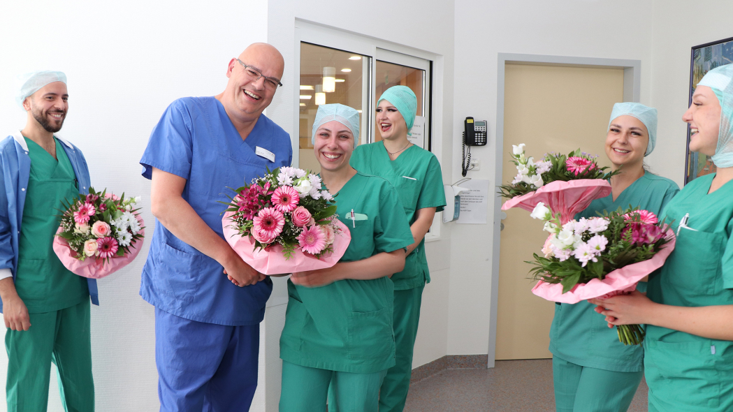 Pflegedirektor Nils Wulf überreicht Blumen an eine der Absolventinnen