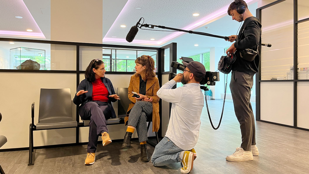 Ein Kamerateam filmt im Krankenhausfoyer ein Interview mit einer Mitarbeiterin.