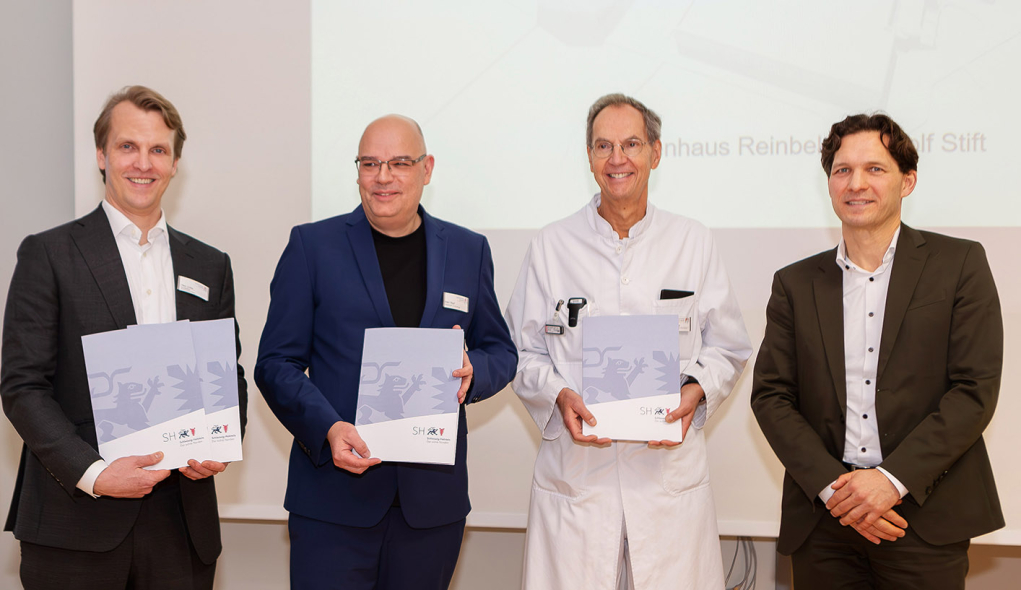 Förderbescheidübergabe in Höhe von fast 40 Millionen an das Krankenhaus Reinbek Das Krankenhausdirektorium hält die 4 Förderbescheide, die Gesundheits-Staatssekretär Dr. Oliver Grundei (r.) im Namen des Gesundheitsministeriums für die großen Bauprojekte des St. Adolf-Stiftes überreicht hat, stolz in den Händen: Krankenhaus-Geschäftsführer Fabian Linke (li.), Pflegedirektor Nils-Michael Wulf und der Ärztliche Direktor Prof. Stefan Jäckle.