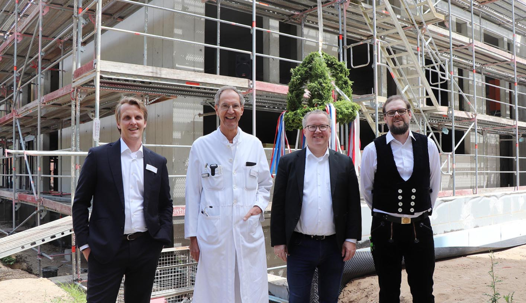 Krankenhausgeschäftsführer, Ärztlicher Direktor, Architekt und Polier stehen beim Richtfest vor dem Neubau des St. Adolf-Stiftes Krankenhausgeschäftsführer, Ärztlicher Direktor, Architekt und Polier stehen beim Richtfest vor dem Neubau des St. Adolf-Stiftes