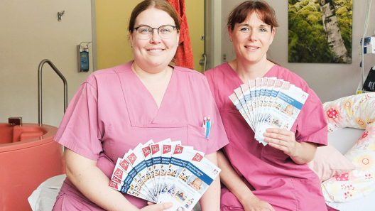 Zwei Mitarbeiterinnnen der Geburtshilfe zeigen die neuen Elternschulflyer